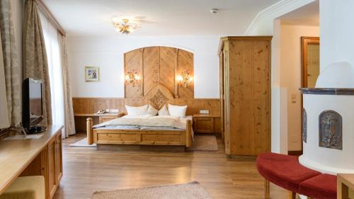 a bedroom with a bed with a wooden headboard at Hotel Garni Castel B&B in Ischgl