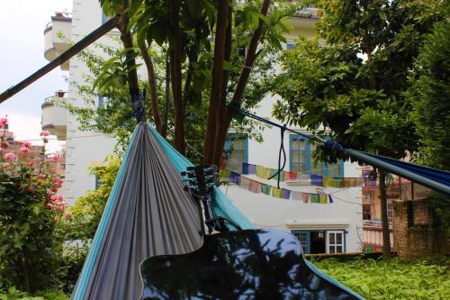 a guitar in a hammock in a garden at KAJI HOME in Pātan