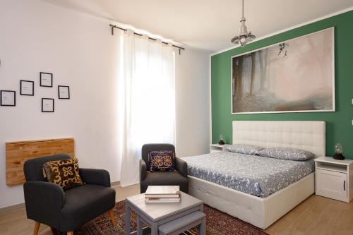 a bedroom with a bed and two chairs at Residence Griffoni in Bologna