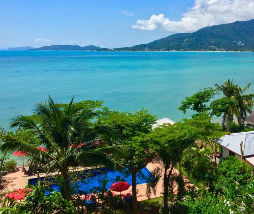 a view of a beach with palm trees and the ocean at Cinnamon Beach Villas in Lamai