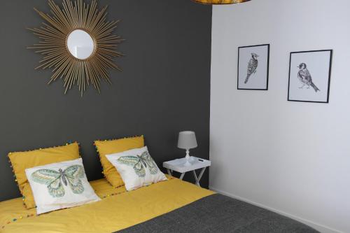 - une chambre avec un lit jaune et un miroir dans l'établissement Une Nuit au Soleil, à Bayeux