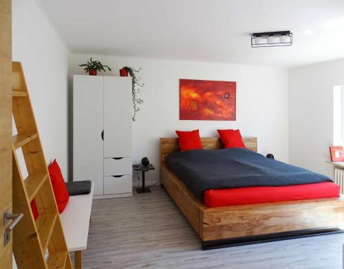 a bedroom with a wooden bed with red pillows at Ferienwohnung beim Burgberg in Bad Abbach