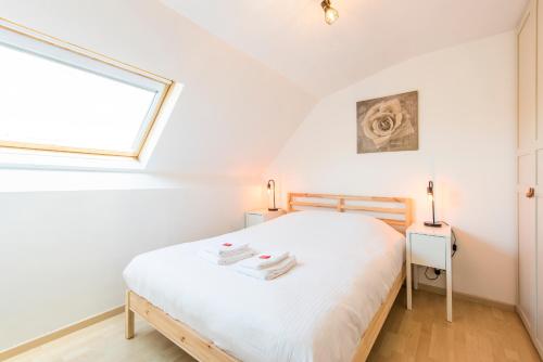 a bedroom with a white bed and a window at Modern and Large 2 bedroom apartment in Middelkerke in Middelkerke