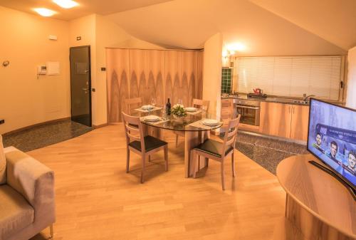 a dining room with a table and a kitchen at Appartamenti Pirovano Bormio in Bormio