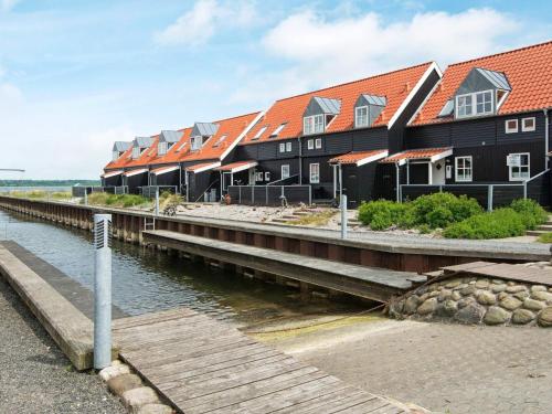 rząd domów na doku obok wody w obiekcie 5 person holiday home in Juelsminde w mieście Juelsminde