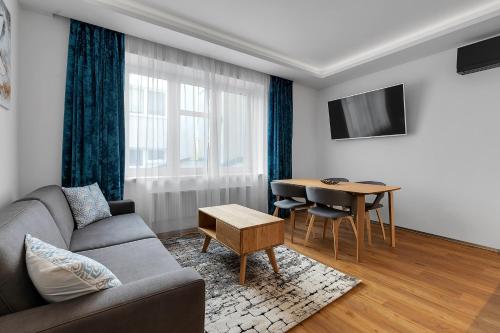 uma sala de estar com um sofá e uma mesa em Nový designový apartmán s klimatizací em Rychnov nad Kněžnou