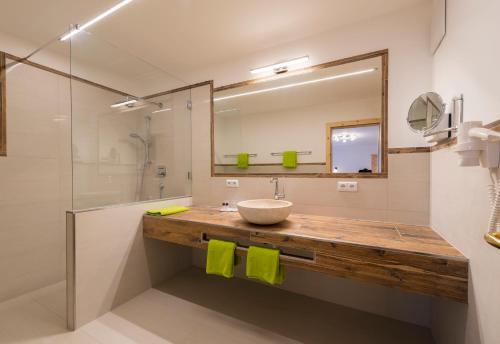 ein Bad mit einem Waschbecken und einem Spiegel in der Unterkunft Hotel Waidachhof in Kössen