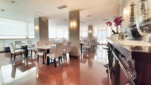 una sala da pranzo con tavoli e sedie in un ristorante di Hotel & Wellness Fra I Pini a Lignano Sabbiadoro