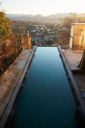 a large pool of water with a city in the background at Boutique Hotel Mendi Argia in Donostia-San Sebastián