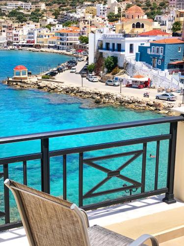 a chair on a balcony with a view of the water at AQUALIA Apartment 1 in Karpathos Town