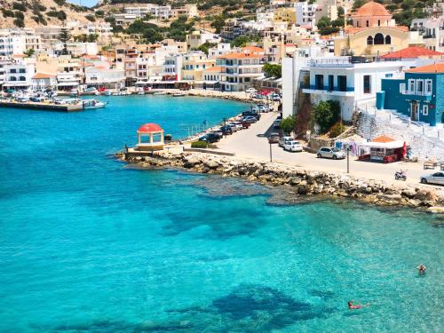 an aerial view of a beach with blue water and buildings at AQUALIA Apartment 1 in Karpathos Town