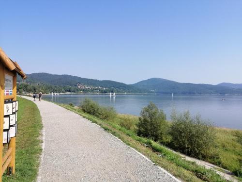 a path next to a body of water at Apartamenty przy Jeziorze Żywieckim z widokiem na Skrzyczne in Żywiec