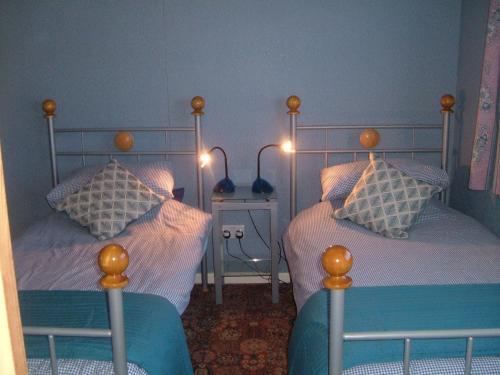1 dormitorio con 2 camas individuales con luces encendidas en Tremains Guest House en Bridgend