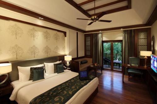 a bedroom with a large bed and a television at Ananta Spa & Resort, Pushkar in Pushkar