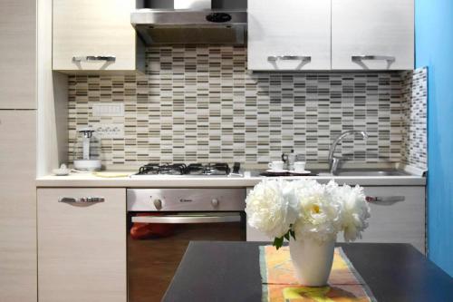 a kitchen with a vase of white flowers on a table at Giardino d'Atri in Naples