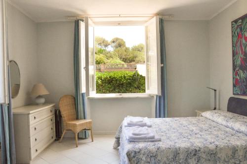 1 dormitorio con cama y ventana en Luxury apartment inside beachfront villa, en Donoratico