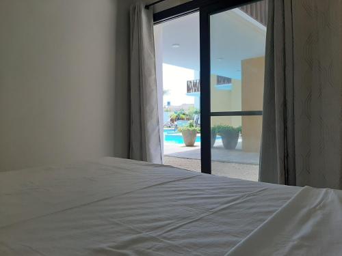 a bedroom with a bed and a view of a pool at Forest View Apartments in Kololi