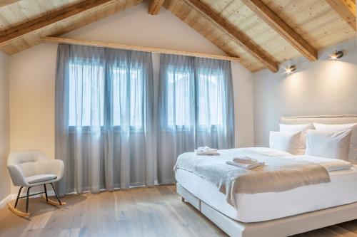 a bedroom with a bed and a chair and a window at Eiche in Interlaken