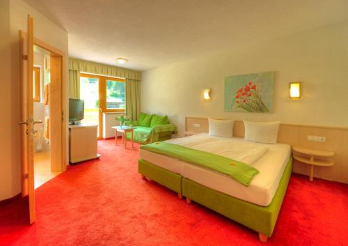 1 dormitorio con 1 cama grande y sala de estar en Apart Garni Sonne en Galtür