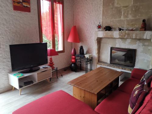 un salon avec une télévision et une cheminée dans l'établissement La Longère du Parc, à Noyers-sur-Cher