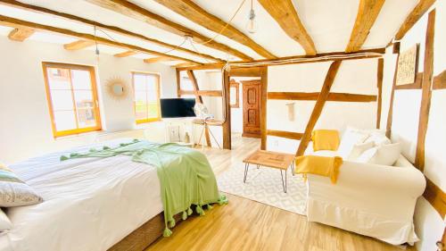 a bedroom with a large bed and a couch at LANDHOTEL 1707 by Landgasthof Zickler in Gleisweiler