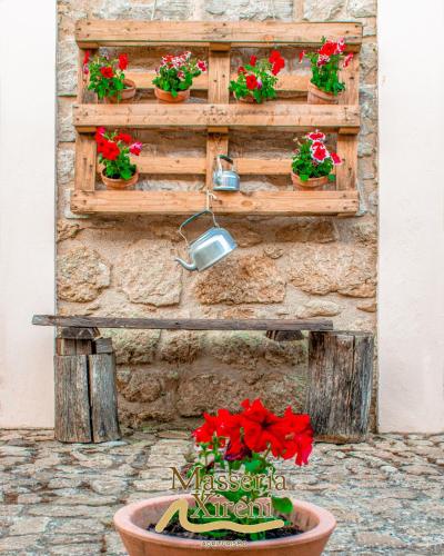 a wooden wall with flowers in a flower pot at Masseria Xireni in Castellana Sicula