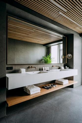 a bathroom with two sinks and a large mirror at Nobu Hotel Warsaw in Warsaw