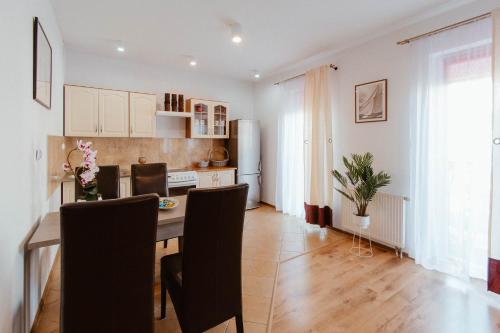 a kitchen and dining room with a table and chairs at Apartament Molo in Giżycko