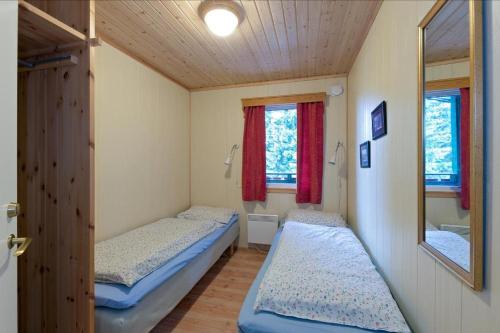 two beds in a small room with a mirror at Trysil Hyttegrend in Trysil
