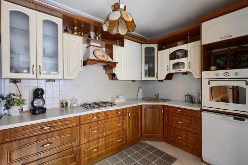 una cocina con armarios de madera y electrodomésticos blancos en Dom z widokiem na Park en Nałęczów