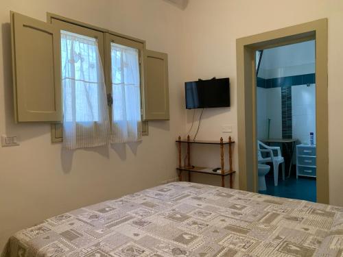 1 Schlafzimmer mit einem Bett, 2 Fenstern und einem TV in der Unterkunft I due Tesori in San Cesario di Lecce