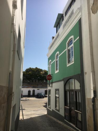 a green building with a stop sign on a street at Casa das Netas in Lagos