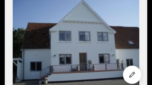 a large white house with a large balcony at Bed & Bath tæt på Nationalpark Vadehavet in Ribe