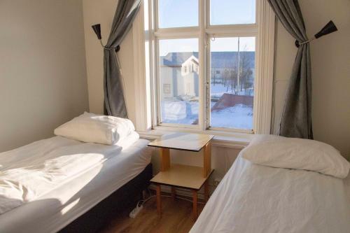two beds in a room with a window at Puffin Hostel Vík in Vík