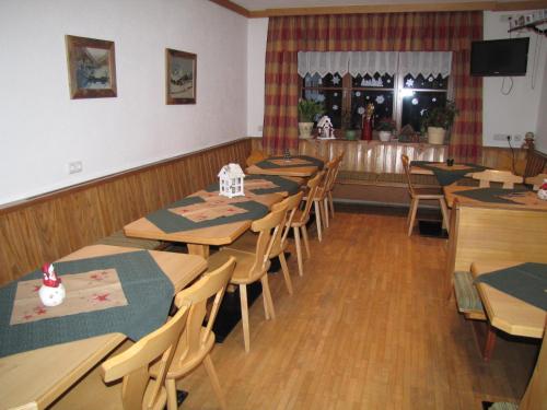ein Restaurant mit Holztischen und -stühlen und einer Theke in der Unterkunft Pension Sydler in Bad Goisern