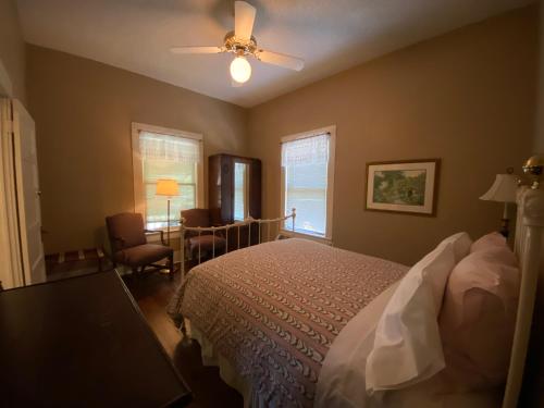 a bedroom with a bed and a ceiling fan at Inn On The River in Glen Rose