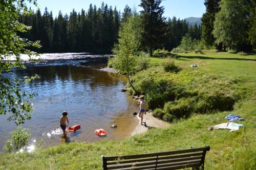 a man and a woman playing frisbee in the water at Trysil Hyttegrend in Trysil