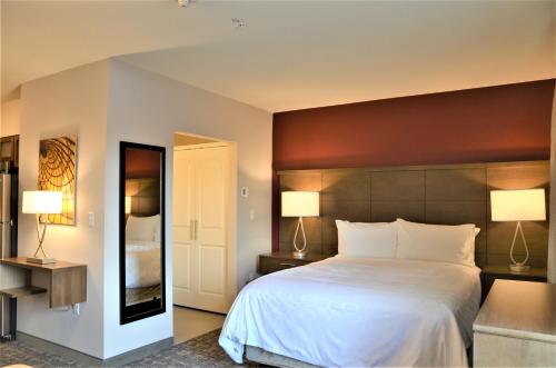 a bedroom with a large white bed and two lamps at Staybridge Suites - Orenco Station by IHG in Hillsboro