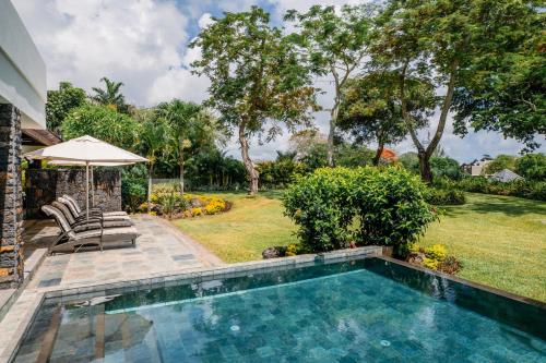a swimming pool in the backyard of a house at Four Seasons Resort Mauritius at Anahita in Beau Champ
