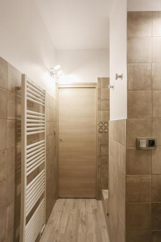 une douche à l'italienne avec une porte en bois dans une salle de bain dans l'établissement SunSet Cassis, à Cassis