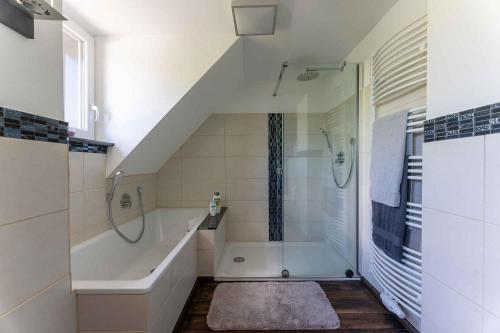a bathroom with a shower and a bath tub at Altes Forsthaus - Ferienwohnung im Obergeschoss in Ormont
