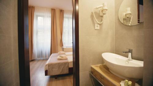 a bathroom with a white sink and a window at Aqua Villa Eger in Eger