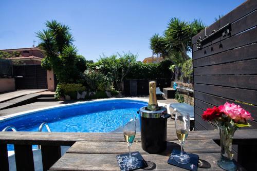 a table with glasses of wine next to a swimming pool at Alojamiento Villa Moles in Salou