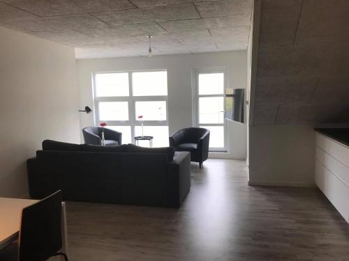 a living room with a couch and two chairs at Lokk-Inn Apartments in Norðdepil