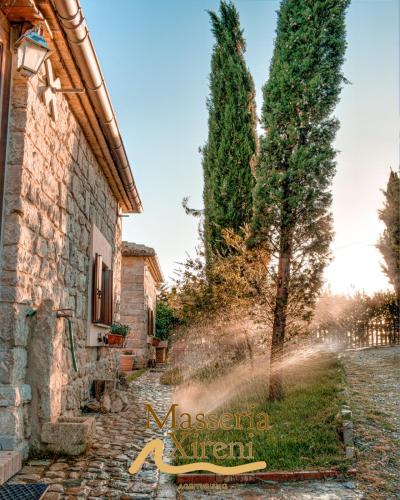 a stone house with a fountain in a garden at Masseria Xireni in Castellana Sicula