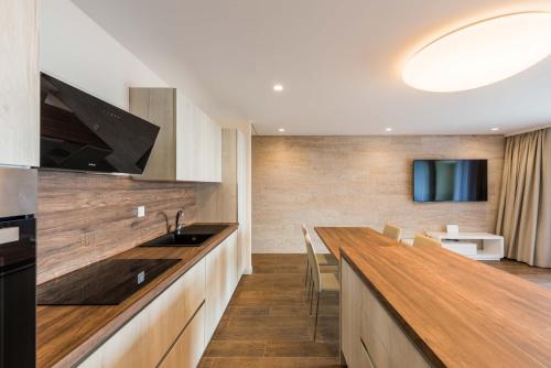 a kitchen with a wooden counter top and a television at Apartment Olijfboom in Dugi Rat