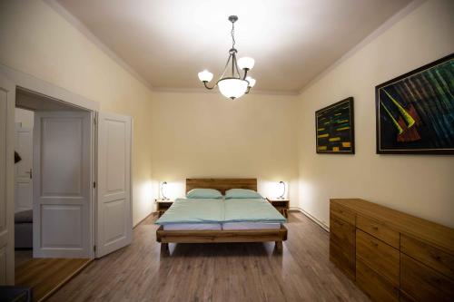 um quarto com uma cama e um lustre em Apartmán Schindlerka em Banská Štiavnica