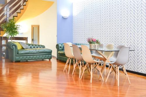 a dining room with a table and chairs and a couch at FlatMILAN in Cernusco sul Naviglio