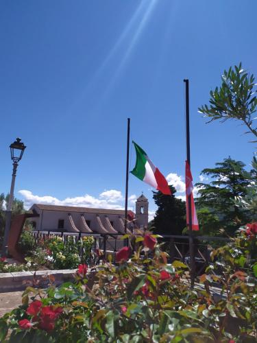 two flags are flying in front of a building at Valle Fiorita in Castro dei Volsci