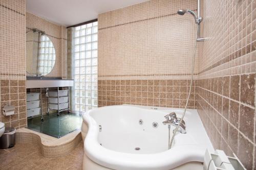 y baño con bañera y lavamanos. en Alojamiento Villa Moles, en Salou